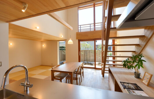 景色を取り込む、大きな木製窓のある住まい